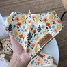 A hand holding a colorful floral bandana with a leather tag that says "SNIFF & DAB".